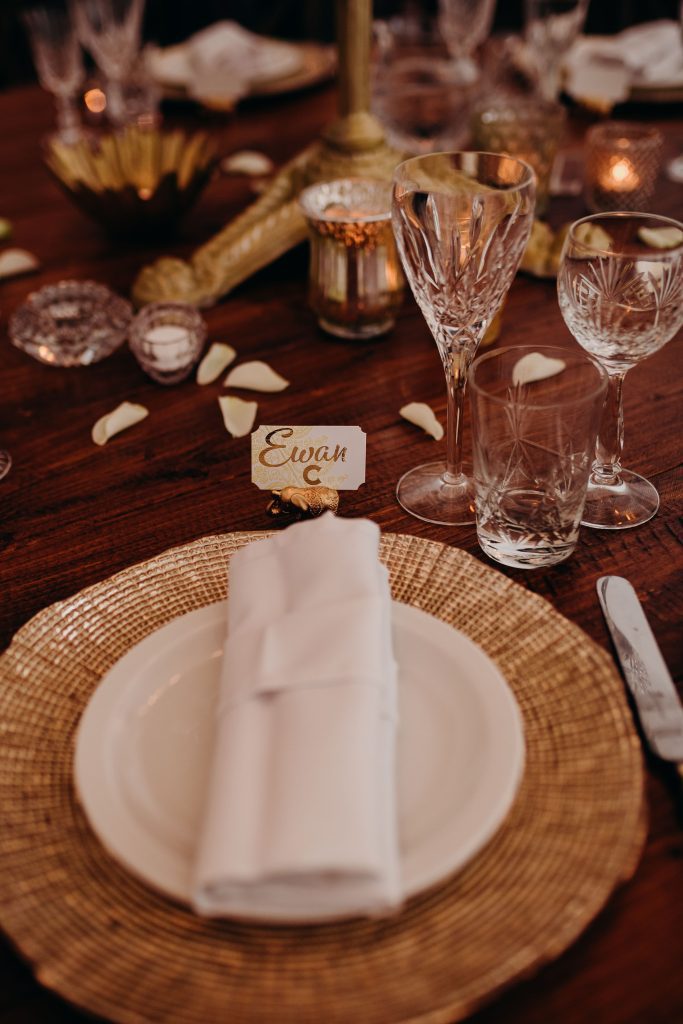 close up of a place setting of a gold charger plate and cut crystal wine, champagne and water tumbler for hire