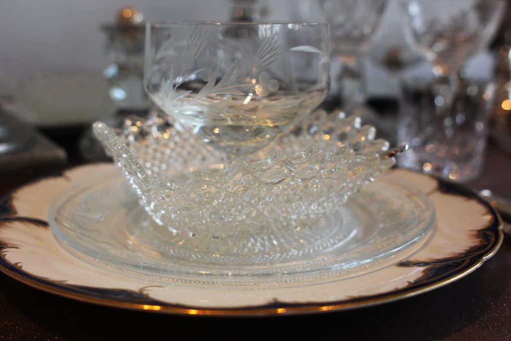 Vintage glass sundae dishes layered up on navy and white vintage plate.