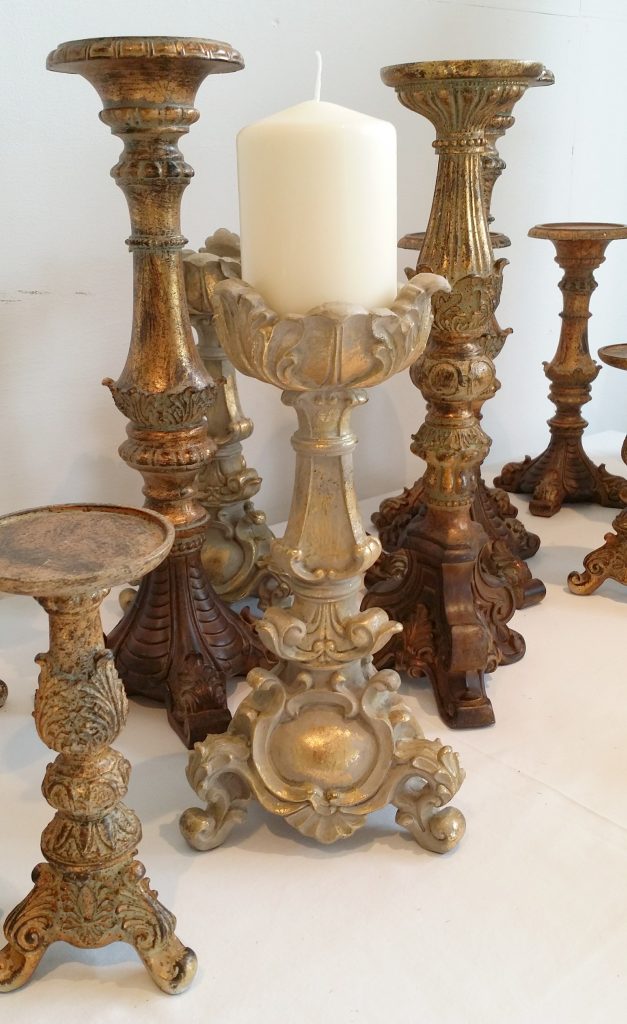 A variety of brass and gold candlestick holders and tealight holders to hire