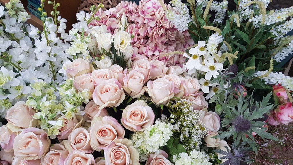 display of luxury quality faux flowers in whites, roses, cosmos, hydrangea, sea thistle, stocks, peonies, and lisianthus perfect to hire for spring weddings and events