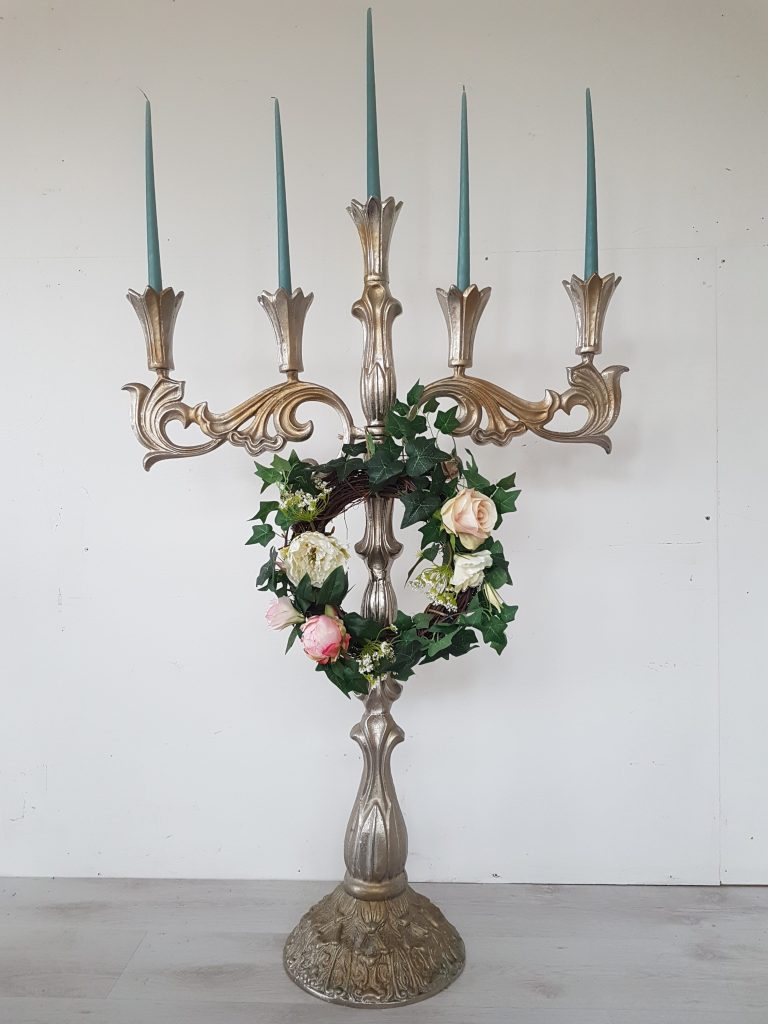 Stunning ornate extra large candelabra with pillar candles and a floral wreath hanging in the centre for hire