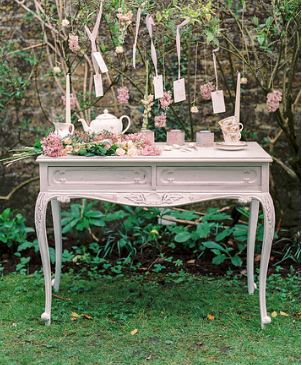 White shabby chic console table with a mini tea party set up on it in pinks for hire