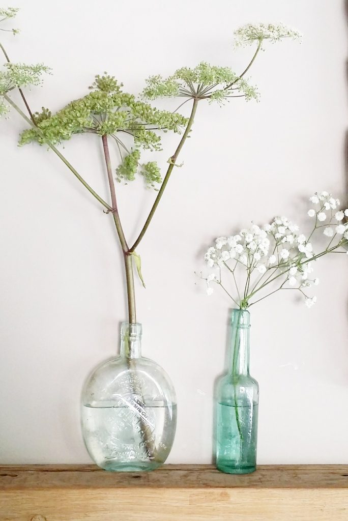 Mixed recycled glass green bottles with cow parsley and gypsophila for woodland wedding flowers lots available to hire