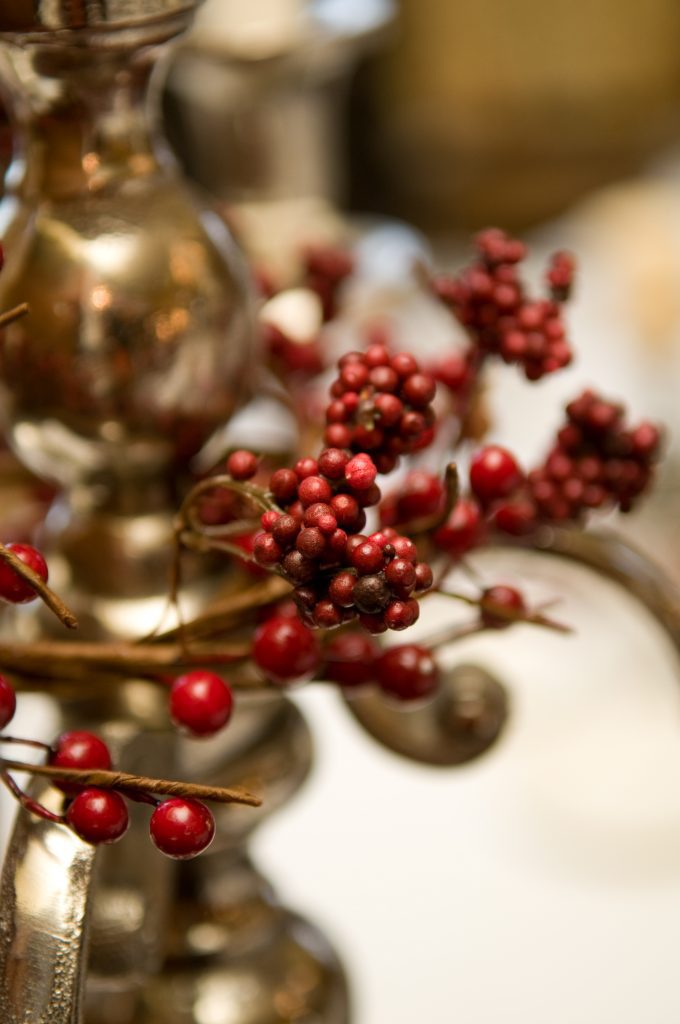 Read winter berry wreaths dressing a silver candelabra as a centrepiece for weddings or Christmas parties