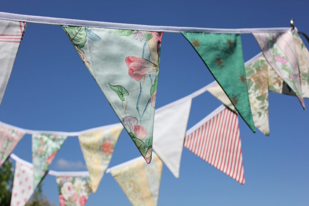 three strings of luxury fabric bunting available to hire for garden parties