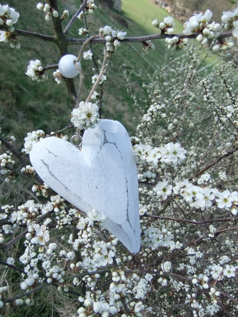 wooden white hanging heart in a white blossom tree for hire on candelabras