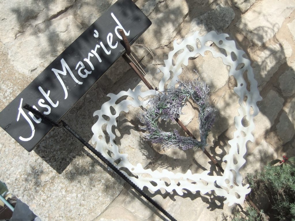 just married sign on stakes with a large hanging hear hanging below