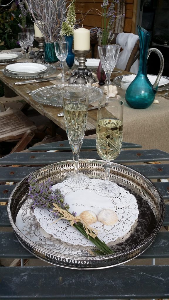 Silver vintage ornate tray with a lace napkin on it and two cut glass champagne flutes filled with prosecco to toast for hire