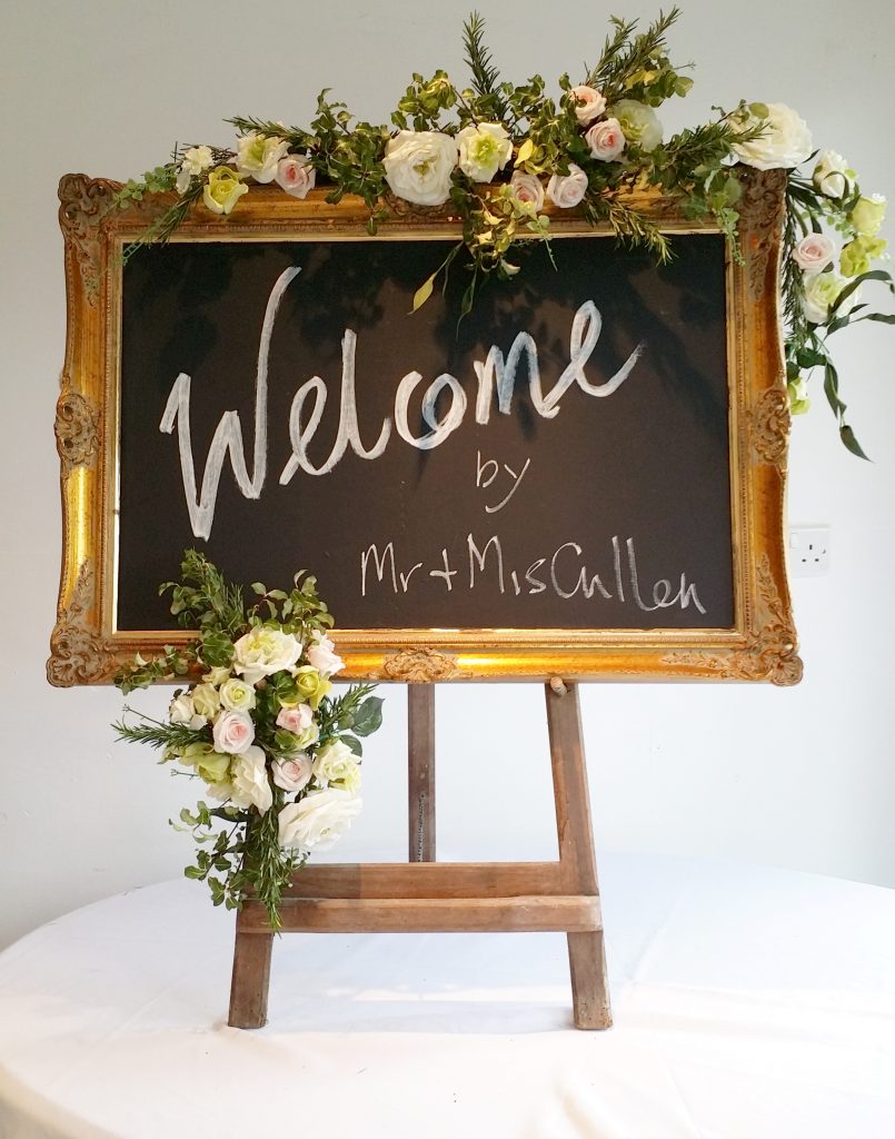 gold frame blackboard on easel with flowers for wedding and event hire