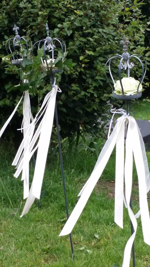 coronet wedding stakes with white ribbon and white roses to hire for weddings, lining the wedding aisle