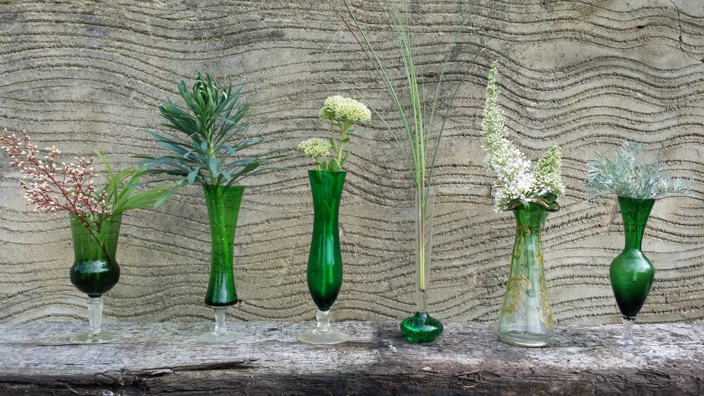 diy wedding table centre idea of vintage coloured vases glass and glass green bottles for hire filled with wild flowers