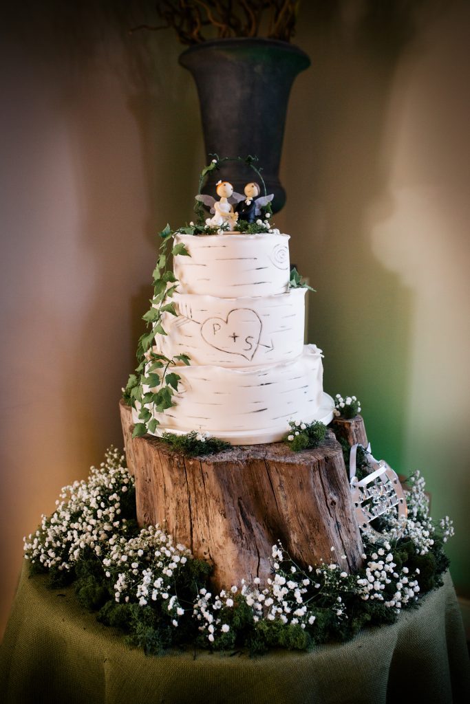 woodland tree stump cake stand wrapped with ivy, moss and gypsophila for wedding cakes available to hire for weddings and events