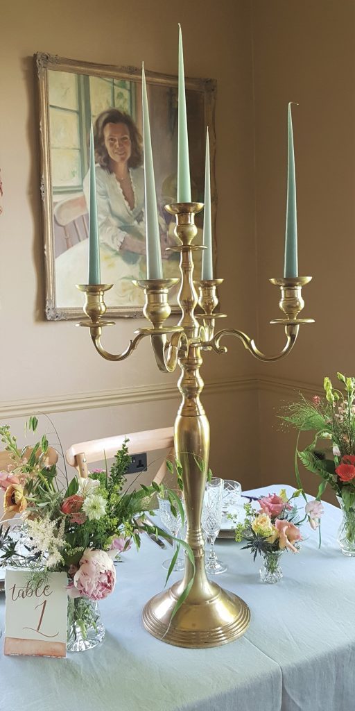 A gold candelabra with aqua candles for hire