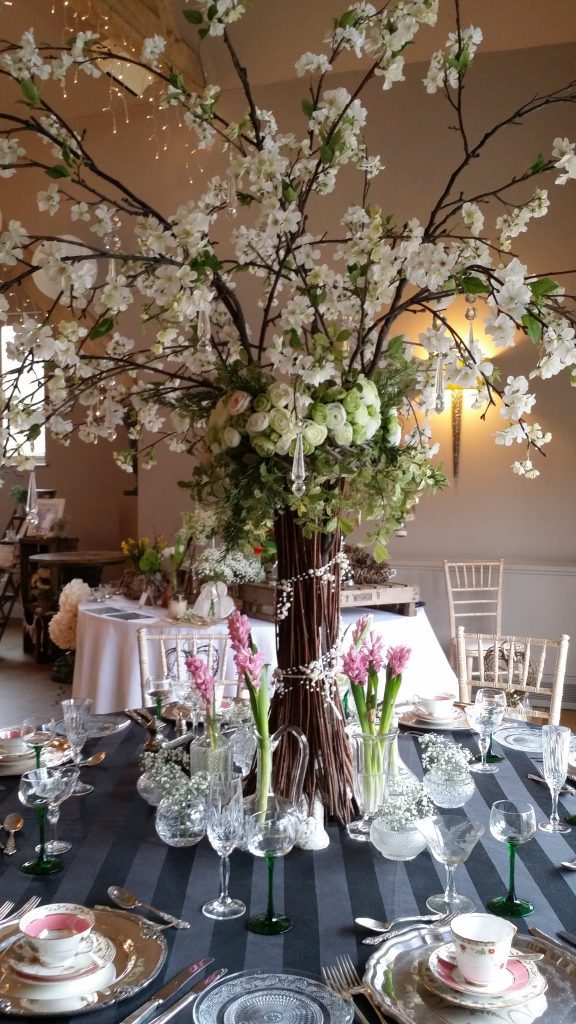 wedding styling table centrepiece with Twigs and blossom tree with cut crystal vases and vintage crockery, teacups and saucers and vintage glasses to hire