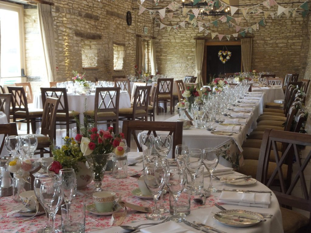 Vintage tea party styled wedding with mix and match vintage crockery and garden party bunting with cut crystal vintage vases filled with wild flowers as centrepieces